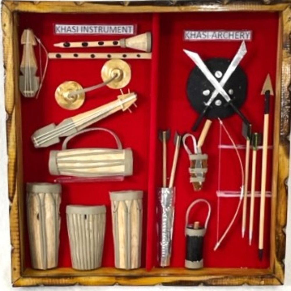 Shadow box miniature Khasi instruments and archery items.